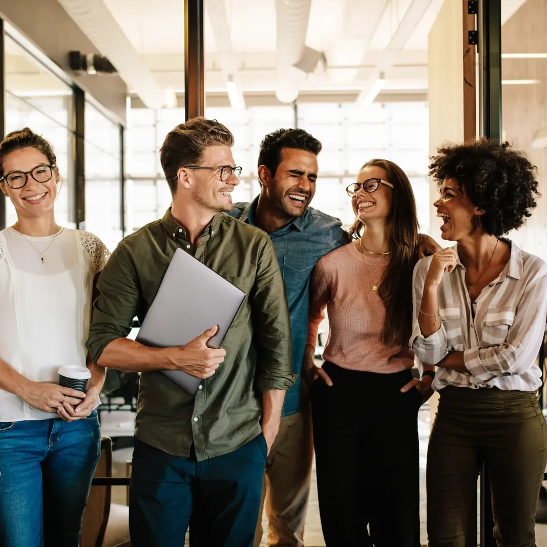 Equipe conversando em ambiente de trabalho claro e aberto