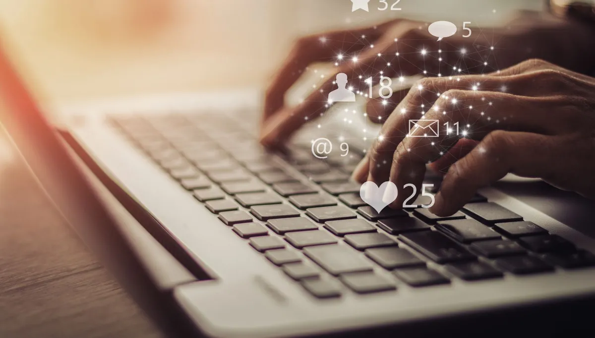 Digitação em computador com símbolos de engajamento ao redor